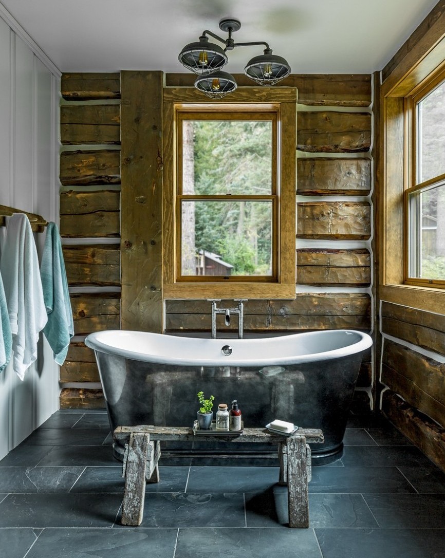 Classic Cabin Style Bathroom with Wooden Log Wall, Tiled Floor, and Free Standing Tub