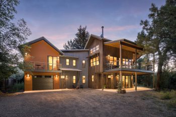 Evening View of Two-Story Cabin Home with Soft Lighting in the Windows