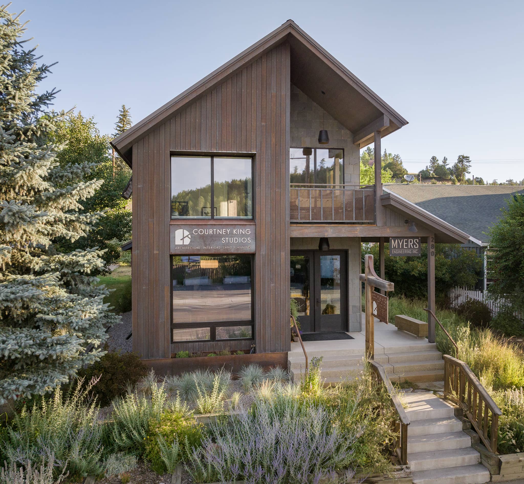 Front View of Builder's Modernized Business Space with Naturalistic Wood Tones and Wild Garden Area